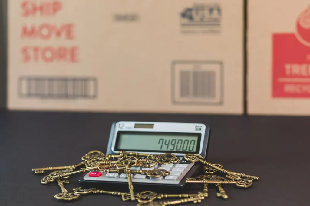 Keys resting on a calculator with moving boxes in the background