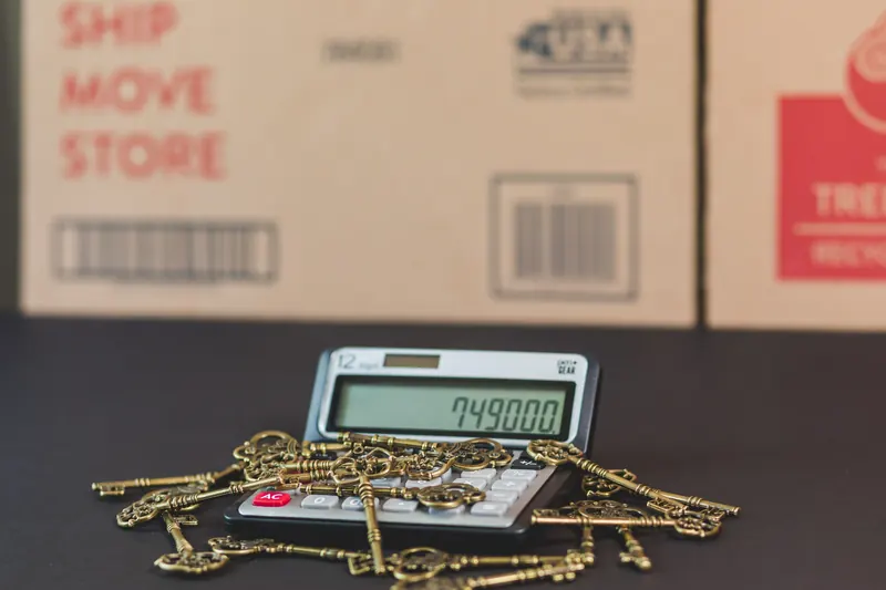 Keys resting on a calculator with moving boxes in the background