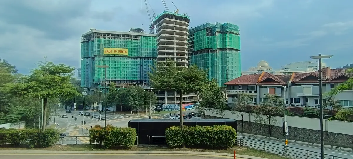 Road junction and residential buildings seen from Publika, including a tower under construction