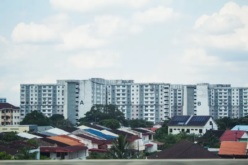 Pitched roof houses in front of apartment blocks in Johor Bahru