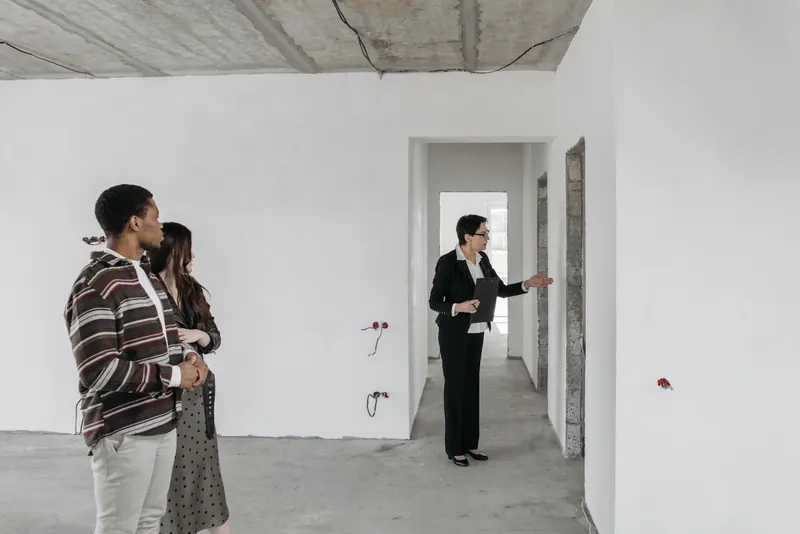 A couple viewing an unfinished apartment with a property agent