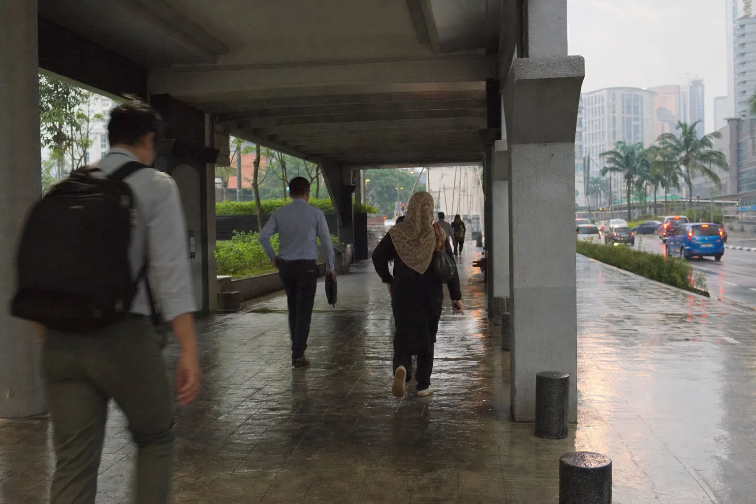 Commuters using a covered pedestrian route in central Kuala Lumpur during rain