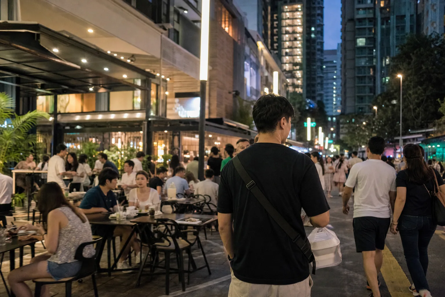 Resident carrying dinner through a busy Bukit Bintang evening street below residential towers
