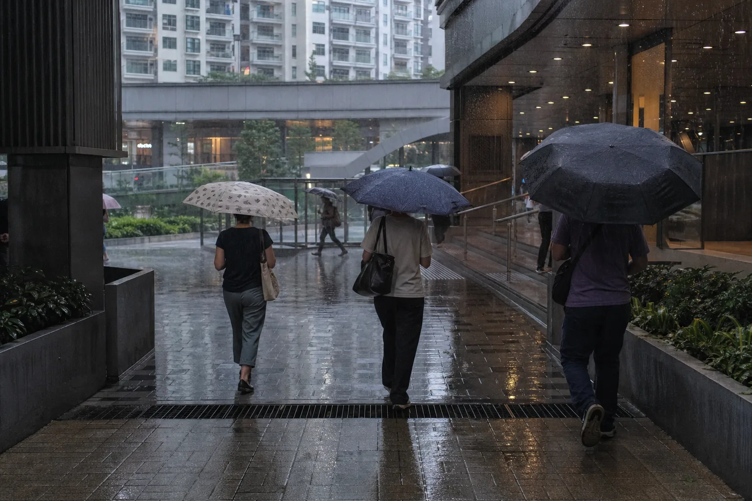 Commuters using umbrellas across an exposed gap in a partially covered TRX-area walking route