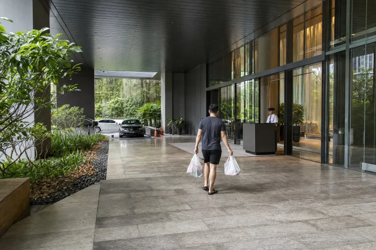 Resident returning with groceries through the covered arrival of a central Kuala Lumpur serviced residence