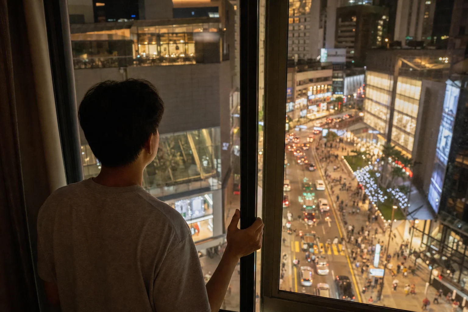 Renter checking night-time street noise from a furnished apartment in Bukit Bintang