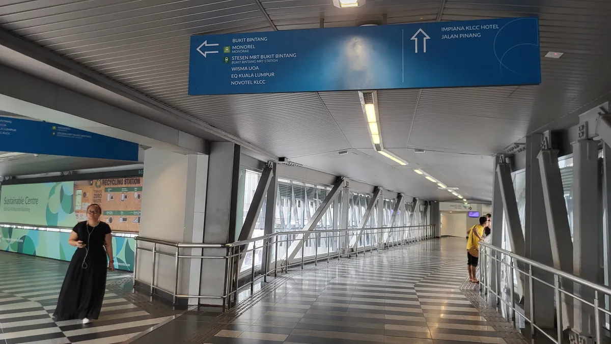 Direction signs inside the covered pedestrian walkway pointing towards Bukit Bintang, Jalan Pinang and nearby buildings