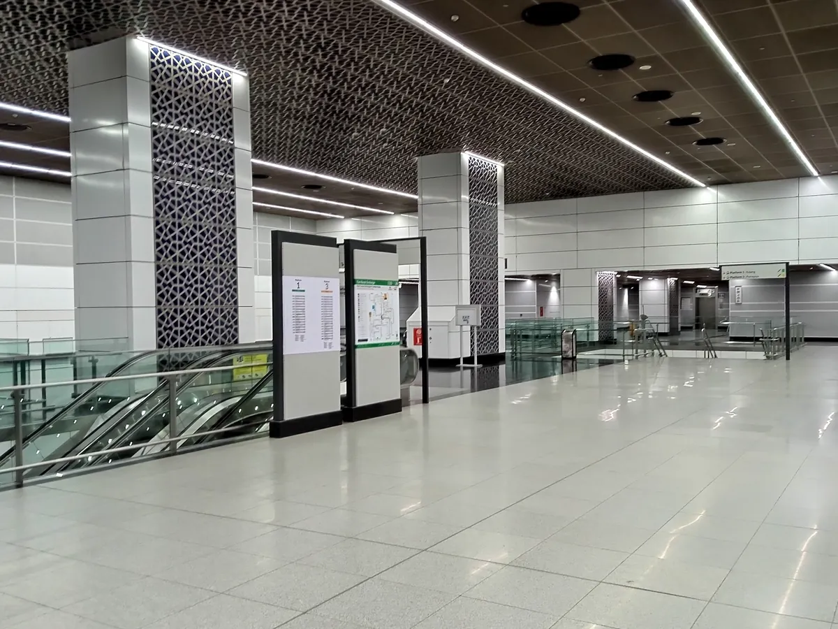 TRX MRT station concourse with escalators, route information and patterned columns