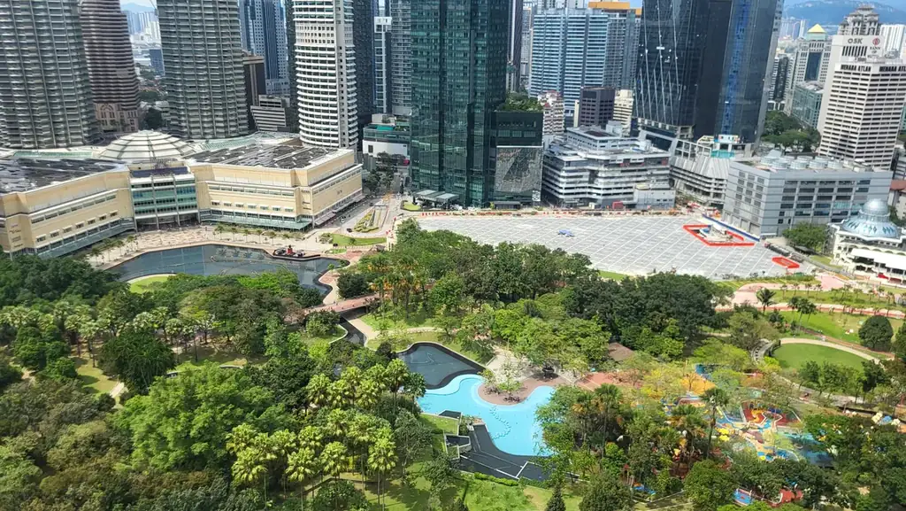 KLCC Park paths, trees and water features beside Suria KLCC and surrounding towers