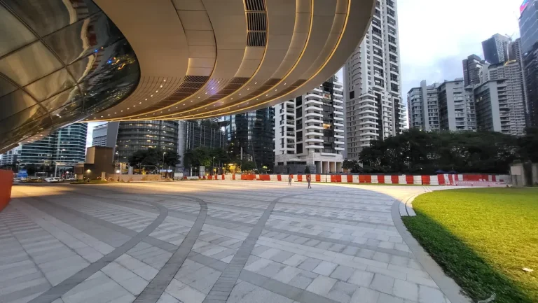 Residential towers and public space seen beneath the Ombak KLCC canopy at dusk